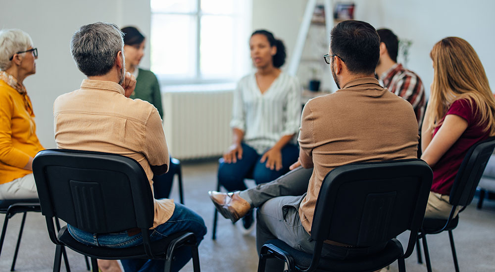 Group of people gathered in circle discussing