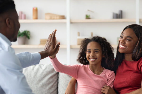Positive black mother and daughter teenager at the appointment with male psychologist