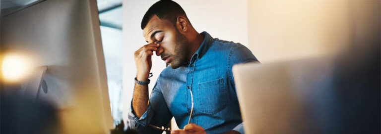 Headache, tired and businessman working in the office with eye strain from the computer or technology.