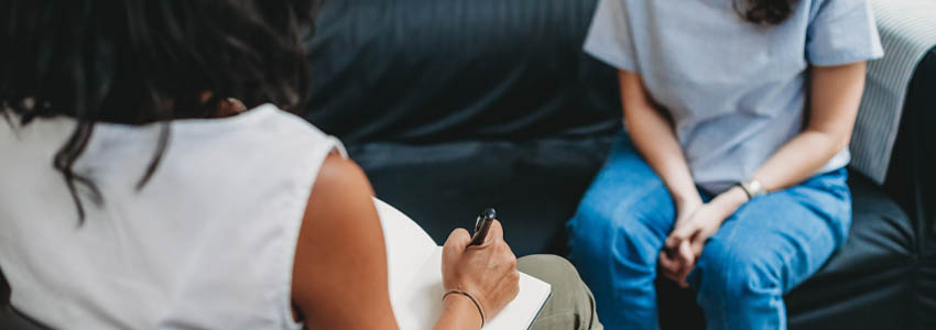 Therapy session with therapist taking notes during visit