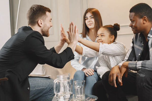 Therapist clapping hands with young girl in therapy