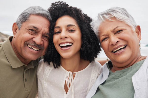 Woman and parents taking photo at beach