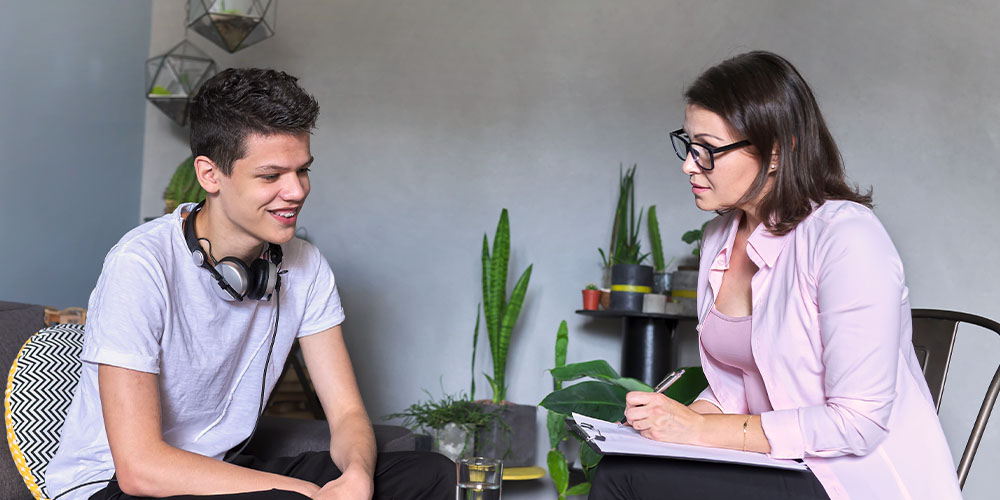 Clinician talking to teenager in office