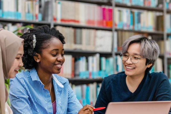 Multiethnic group of students sitting in a library and studying together