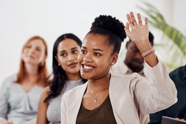 Young woman raising hand during discussion